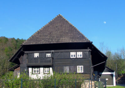 Am ältesten Haus des Dorfes befinden sich Berufssymbole des Schneiderhandwerks. Drei Schneider-Generationen lebten in dem 1734 erbauten Haus.