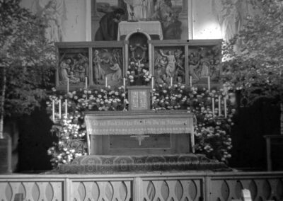 Blick in den Altarraum der neuen Kirche in den 1930er-Jahren. Der Blumen- und Birken-Schmuck weist auf ein Hochfest hin.