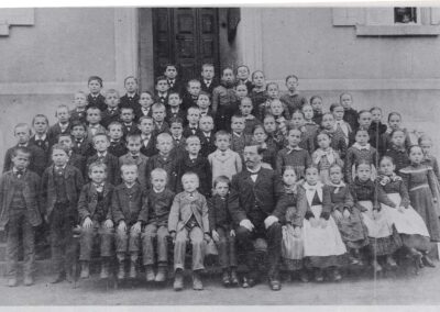Schulverwalter Markus Alfery mit seinen Schülern vor dem Schul- und Rathaus im Jahre 1900.