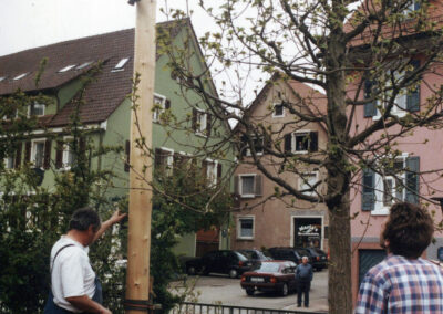 Erstes Maibaumstellen 2001: Unterstützt durch den Gemeindebagger bringen die Baumsteller den Baum in die Senkrechte.