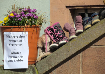 Gründonnerstag 2021: Impressionen von der Protest-Aktion am Dörlinbacher Rathaus. Kinderschuhe und Kuscheltiere säumen die Treppe und im Wind flattern kleine Plakate und Zettel.
