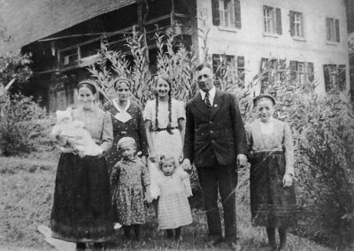 Die Wanglers präsentieren sich vor ihrem Hofgut (Wanglerhof): Hofbauer Wilhelm Wangler mit Ehefrau Maria (geb. Hupfer) und den Familienangehörigen.