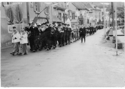 Prozession durch die Hauptstraße bei einem Johannisfest in den 1950er-Jahren. Angeführt von der Musikkapelle, das ist auch heute noch so.