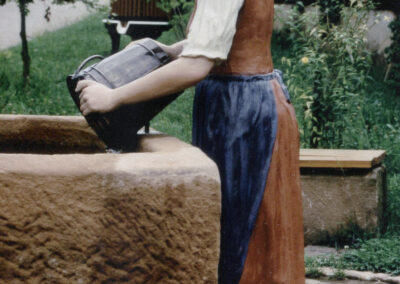 Die Figur am 1996 geschaffenen Buchbrunnen beim Zieglerhof (heute Ziegelhof). Die bemalte Sandsteinfigur wurde durch eine Bronzefigur im Jahre 2003 ersetzt.