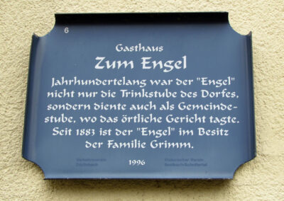 Die Infotafel am Gasthaus „Zum Engel“. Sie weist auf die Historie des Gasthauses hin, das aus einer Trinkstube aus dem 14. Jahrhundert hervorging.