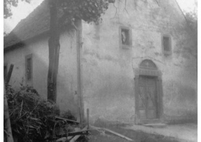 Blick auf den Eingangsbereich zur Kapelle Zu Ehren der Heiligen Dreifaltigkeit. Das kleine Kirchlein wurde 1922 zugunsten einer größeren Kirche abgerissen.