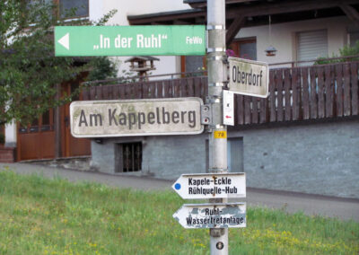 Der Schilderwald an der Weggabelung Am Kappelberg und Oberdorf. Unten befinden sich der kuriose Wegweiser mit den Rechtschreibfehlern.