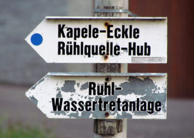 Der kuriose Wegweiser mit den Rechtschreibfehlern. Statt „Kapelle“ heißt es auf dem Schild „Kapele“ und statt „Ruhlquelle“ heißt es „Rühlquelle“.