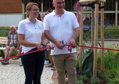 Bürgermeister Matthias Litterst und Gemeinderätin Julia Zehnle durchschneiden ein Band zur symbolischen Öffnung des „Mühlenplatzes“.