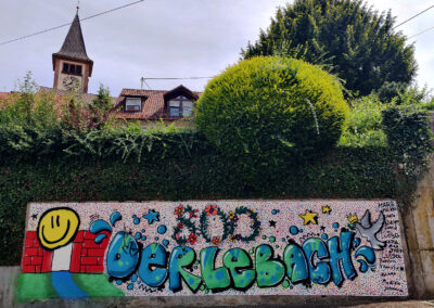 Geschafft: Das farbenfrohe Kunstprojekt der Jugend ziert nun den Parkplatz bei der Alten Schule – mitten im Dorf.