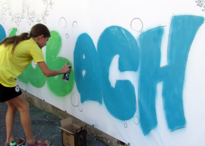 Momentaufnahmen von der Graffiti-Aktion der Dörlinbacher Jugend bei der Alten Schule. 15 Jugendliche eine triste Stützmauer in ein leuchtendes Wandbild.