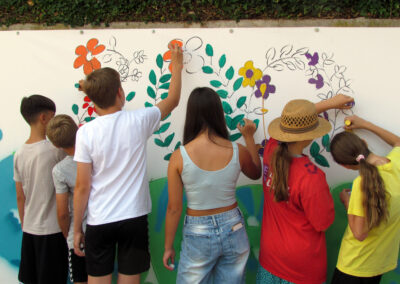 Momentaufnahmen von der Graffiti-Aktion der Dörlinbacher Jugend bei der Alten Schule. 15 Jugendliche eine triste Stützmauer in ein leuchtendes Wandbild.