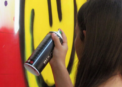 Momentaufnahmen von der Graffiti-Aktion der Dörlinbacher Jugend bei der Alten Schule. 15 Jugendliche eine triste Stützmauer in ein leuchtendes Wandbild.