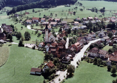 Blick aus einem Kleinflugzeug auf Dörlinbach in den 1980er-Jahren. Der Ortskern, links die Siedlung, oben das Neubaugebiet Kappelberg sowie die Kapelle.